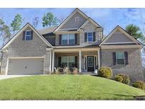 Charming two-story brick home featuring a spacious two-car garage and a well-manicured lawn at 4596 Birch Way, Loganville, GA 30052