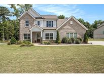 Two-story brick home with landscaped lawn and driveway at 220 Seth Ter, Mcdonough, GA 30252