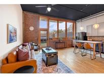 Open living area with exposed brick, hardwood floors, and large windows at 660 Glen Iris Ne Dr # 204, Atlanta, GA 30308