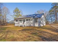 Newly renovated farmhouse features a front porch and large yard at 206 Hunters Ln, Powder Springs, GA 30127