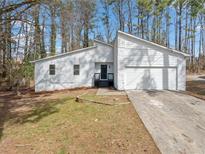 Charming single Gathering home featuring white siding, a two-car garage, and a well-maintained front yard at 3364 Sheree Trl, Stone Mountain, GA 30087