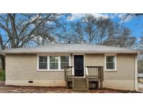 Beige brick ranch house with a wooden deck and black front door at 568 Mcwilliams Se Rd, Atlanta, GA 30315