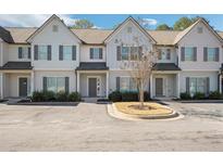 Three-unit townhome building, light gray siding, front entryways, and landscaping at 7744 Fawn Cir, Covington, GA 30014