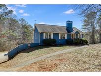 Charming single-story home with blue siding, white trim, and a neatly landscaped front yard on a sunny day at 446 Mcgukin Rd, Bremen, GA 30110