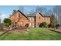 Brick house with landscaped lawn at 24 Planters Sw Dr, Lilburn, GA 30047