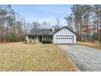 Charming single-story home featuring stone accents, a covered porch, and a two-car garage at 70 Ashton Pl, Covington, GA 30016