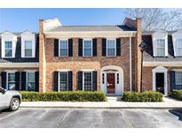 Charming brick townhome with black shutters and manicured landscaping at 15 Kings Tavern Nw Pl, Atlanta, GA 30318