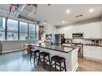 Open kitchen with a large island, granite countertops, stainless steel appliances, and hardwood floors at 33 Ponce De Leon Ne Ave # 203, Atlanta, GA 30308