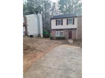 Traditional two-story home showcasing a brick facade, red shutters, and a quaint front yard at 5581 Marbut Rd, Lithonia, GA 30058