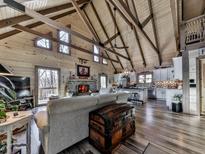 Stunning living room featuring wood-paneled walls, vaulted ceilings, and a stone fireplace at 255 Marks Way, Canton, GA 30115
