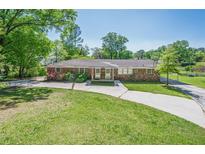 Brick home featuring a well-manicured lawn, mature trees, and a long driveway at 3710 Lynn Dr # A & B, Powder Springs, GA 30127