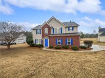 Two-story house with brick and siding, blue shutters, and a landscaped lawn at 7085 Magnolia Ln, Fairburn, GA 30213