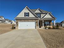 Two-story house with stone accents and a three-car garage at 1455 Weeping Tree Cir, Auburn, GA 30011