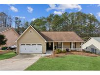 Tan house with white columns, two-car garage, and a manicured lawn at 2900 Dogwood Creek Pkwy, Duluth, GA 30096