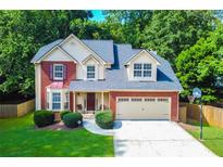 Charming two-story brick and vinyl home with manicured lawn and a two car garage at 2548 Brentmoor Ct, Suwanee, GA 30024