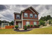 Brick two-story house with gray shutters, landscaping, and a manicured lawn at 7053 Creststone Way, Lithonia, GA 30038