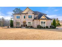 Stately brick home with manicured landscaping and mature trees creating a welcoming curb appeal at 5269 Heron Bay Blvd, Locust Grove, GA 30248