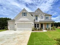 Inviting two-story home with white brick, light turquoise shutters and professionally landscaped front yard at 679 Crest Line Trl, Powder Springs, GA 30127
