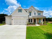 Charming two-story home features a white brick facade, manicured lawn, and an attached three-car garage at 679 Crest Line Trl, Powder Springs, GA 30127
