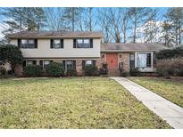 Attractive two-story house with brick and siding exterior, landscaping, and walkway at 1519 Carnaby Ct, Dunwoody, GA 30338