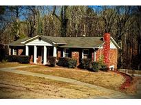 Brick ranch house with a large front yard and wooded backdrop at 4610 Spring Valley Pkwy, South Fulton, GA 30349