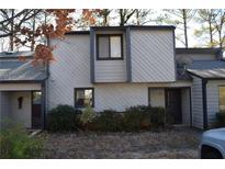 Two-story townhouse with gray and white siding and dark trim, surrounded by bushes and a small tree at 288 Heathersett Sw Dr, Marietta, GA 30064