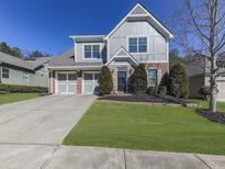 Two-story house with gray siding, brick accents, and a two-car garage at 217 Towering Peaks, Canton, GA 30114