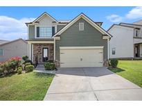 Two-story house with a neutral-colored exterior, stone accents, and a two-car garage at 4367 Favored Way, Union City, GA 30291