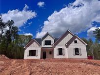 Charming single-Gathering home with neutral siding, black trim, and a well-lit interior against a partly cloudy sky at 130 West Lake Blvd, Carrollton, GA 30116