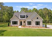 Charming home featuring a well-manicured lawn and neutral exterior with black shutters at 130 West Lake Blvd, Carrollton, GA 30116