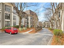 Exterior of condo building with parking, landscaping, and trees on a sunny day at 2657 Lenox Ne Rd # A-9, Atlanta, GA 30324