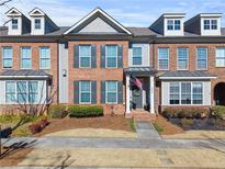 Brick front exterior of charming townhome with gray accents and landscaping at 256 S Village Sq, Canton, GA 30115