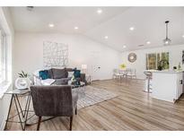 Open concept living room featuring modern decor, wood floors, and vaulted ceilings at 1428 Muirfield Dr, Stone Mountain, GA 30088