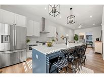 Modern kitchen featuring stainless steel appliances, large island with seating, and stylish lighting at 720 Perch Pl, Atlanta, GA 30312