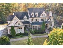 Stately stone home with a manicured front yard and mature trees, exudes curb appeal and timeless elegance at 5021 Heatherwood Ct, Roswell, GA 30075