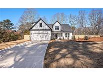 Two-story farmhouse features a white exterior, gray roof, and attached garage at 3900 Arbor Se Ln, Conyers, GA 30094