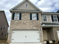 Charming two-story townhome featuring a brick facade, attached garage, and decorative shutters at 2861 Fareed St # 40, Douglasville, GA 30135