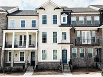 Beautifully designed townhomes feature a mix of brick and siding, with front porches and symmetrical windows at 2531 High Brow St # 41, Duluth, GA 30096