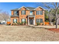 Traditional brick home featuring manicured landscaping, black shutters, and a welcoming entryway at 5447 Stirrup Way, Powder Springs, GA 30127