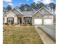 Charming single-story home featuring a well-manicured lawn and attached two-car garage at 7417 Jennadee Dr, Fairburn, GA 30213