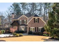 Beautiful brick home featuring a manicured front lawn and mature trees at 1581 Aragon Ne Way, Brookhaven, GA 30319