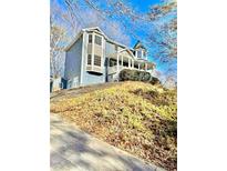 Charming blue two-story home with a large wrap-around porch and beautiful bay windows at 2610 Woodridge Chase, Canton, GA 30114