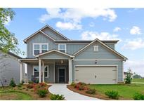 Two-story house with gray siding, beige garage door, and landscaping at 3152 Birdsong Ave, Covington, GA 30016