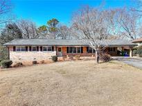 Charming brick home featuring a well-maintained lawn and a cozy carport at 4589 Mesaview Way, Stone Mountain, GA 30083