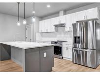 Bright kitchen features a gray island with a white countertop and stainless steel appliances at 515 Federal Se Ter, Atlanta, GA 30315