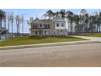 Inviting two-story home featuring a well-manicured lawn, brick facade, and a charming light blue front door at 318 Delta Dr, Mcdonough, GA 30253