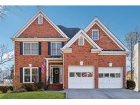 Two-story brick home with a two-car garage and manicured lawn at 1464 Oglethorpe Dr, Suwanee, GA 30024