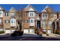 Brick townhouses with attached garages and landscaping at 2969 Rivergreen Se Ln, Atlanta, GA 30339