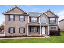 Brick two-story house with a large front yard and landscaping at 5010 Mundy Dr, Cumming, GA 30028