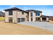Stunning modern home featuring a brick facade, black trim, a spacious driveway, and a two-car garage at 2753 Camp Branch Rd, Buford, GA 30519